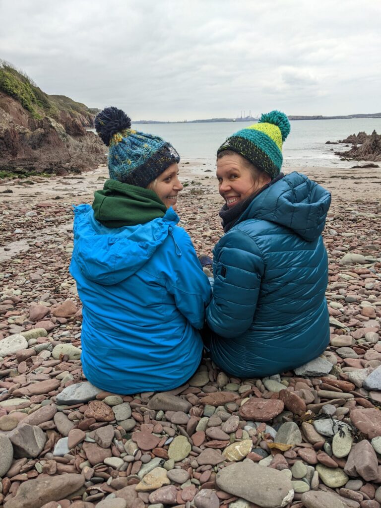 2 Swimmers on the beach with coats and hats on